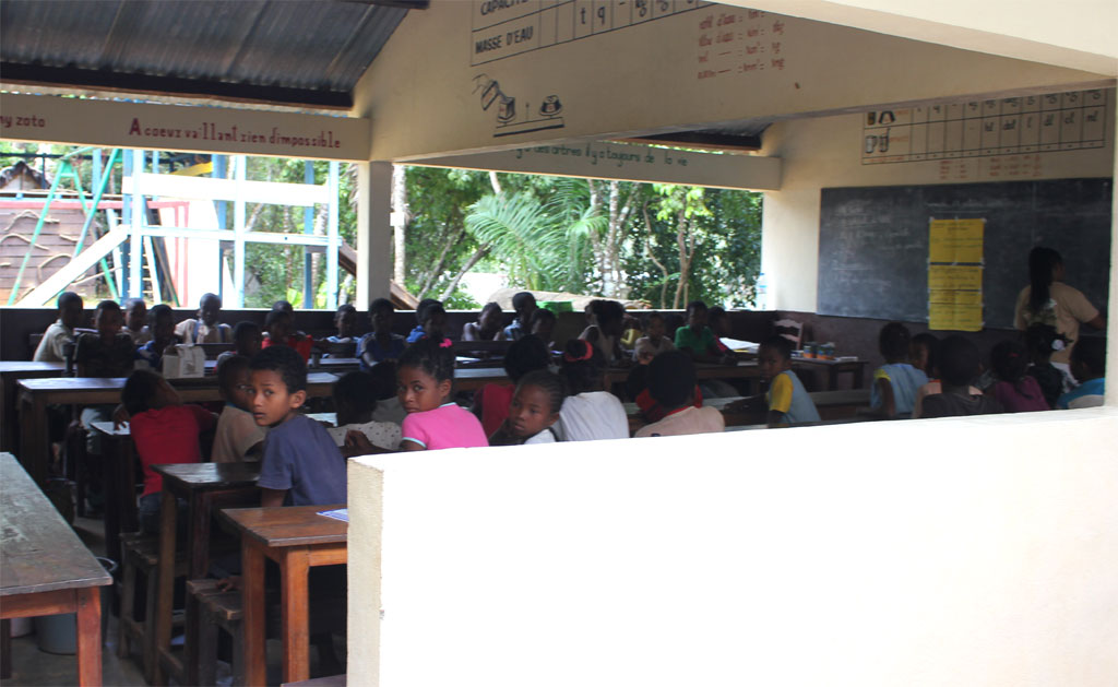 Een groep kinderen krijgt les in een open klaslokaal